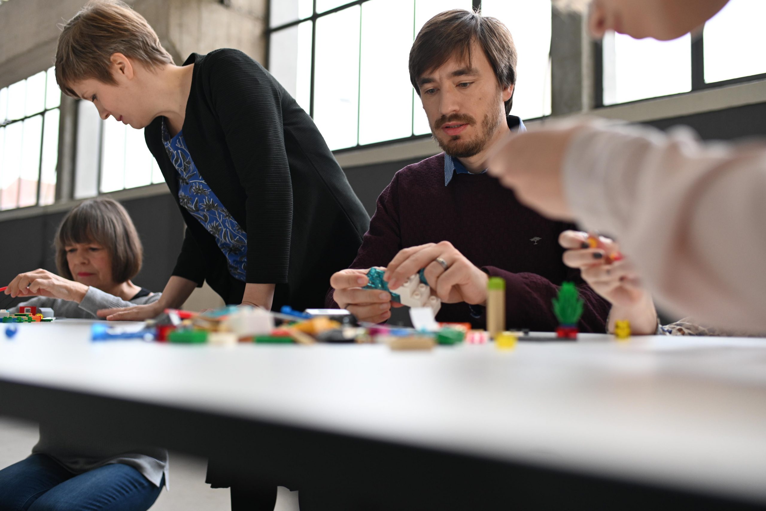 Teilnehmer im Teamworkshop arbeiten mit Lego
